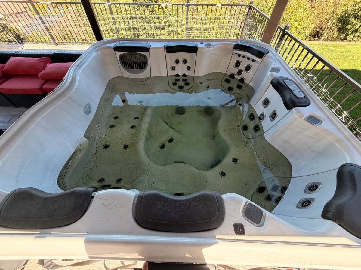 Hot tub with cloudy, dirty green water before a Granite Spa Services deep clean